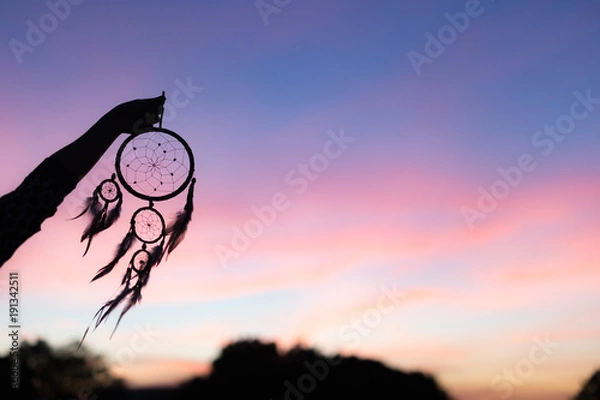 Obraz Silhouette of Dream Catchers hold up in the air during sunset period