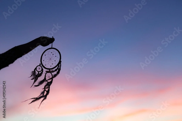 Obraz Silhouette of Dream Catchers hold up in the air during sunset period