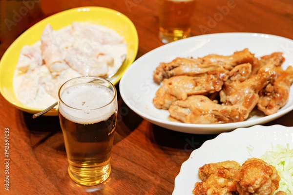 Obraz 鶏肉料理とビールの賑やかな晩酌の食卓