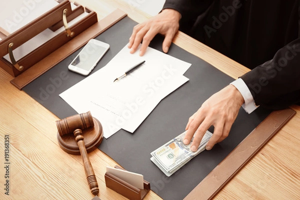 Fototapeta Mężczyzna sędzia z łapówką przy stole, zbliżenie