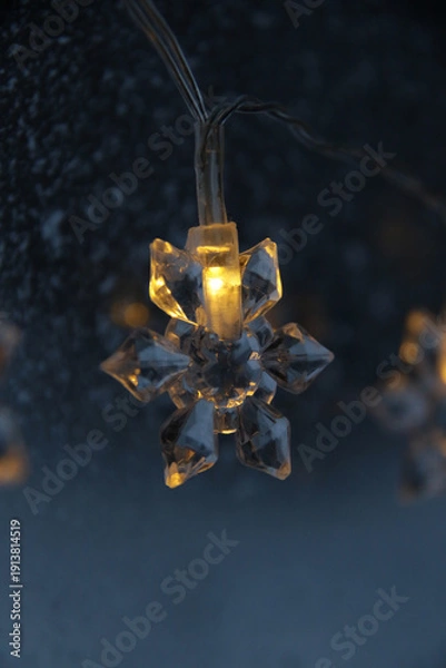 Obraz decorative snowflake light string on frosty window