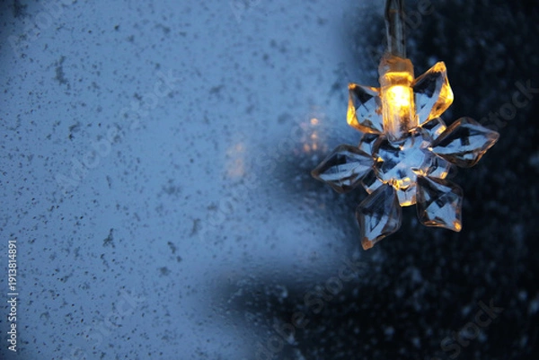 Obraz decorative snowflake light string on frosty window