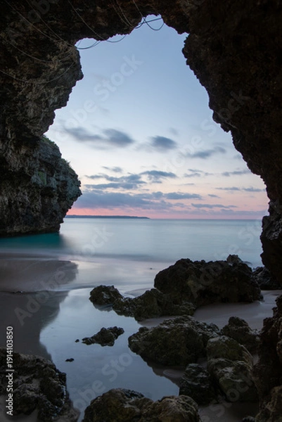 Obraz 宮古島の砂山ビーチで岩のトンネルとトワイライトに染まる夕暮れの海