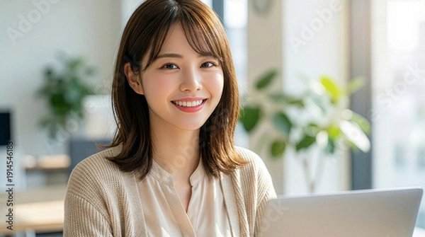 Obraz 明るい室内でパソコンを操作する笑顔のビジネスウーマン