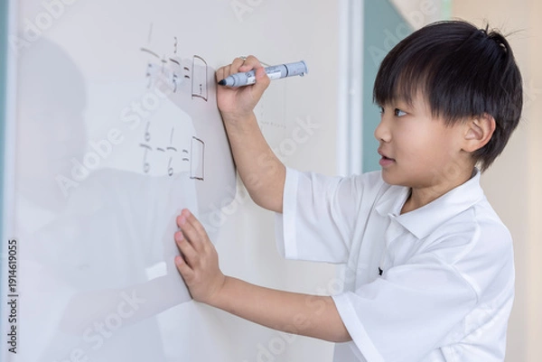 Obraz ホワイトボードに分数を書き込む小学生