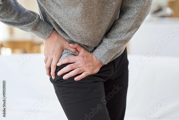 Obraz 股関節が痛くて苦しむアジア人男性