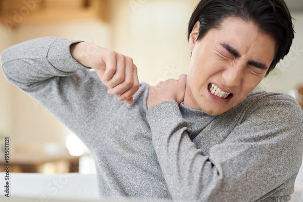 Obraz 肩が痛くて腕を回すアジア人男性