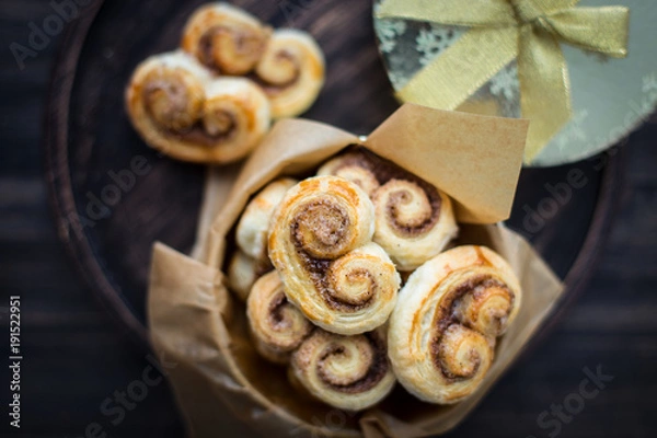Fototapeta Cookies, curlicues, pretzels of puff pastry with sugar and cinnamon