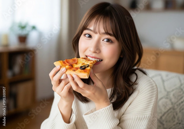 Obraz 自宅でリラックスしながら焼きたてのピザを頬張り微笑む女性