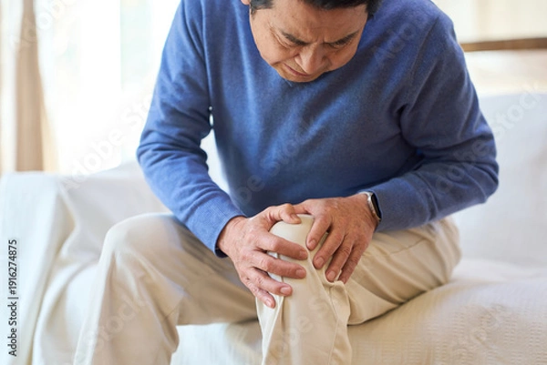 Obraz 痛む膝を押さえるアジア人シニア男性