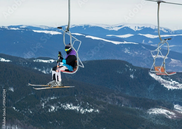 Fototapeta skier on a platform on a background of high snow mountains.