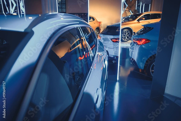 Fototapeta fashionable bright auto show A number of new cars parked in the car dealers' warehouse, modern design of the room with mirrors