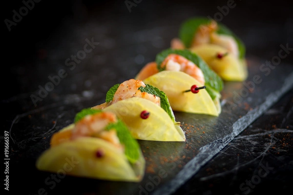 Fototapeta shrimp appetizers on black plate 