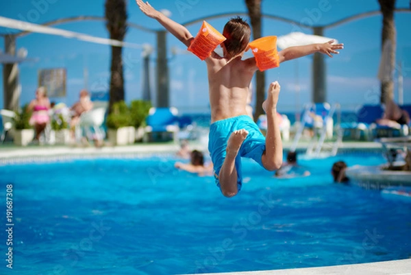 Obraz Caucasian boy jumping into the pool.