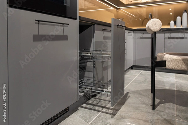 Fototapeta Pull-out kitchen cabinet with empty chrome cargo basket