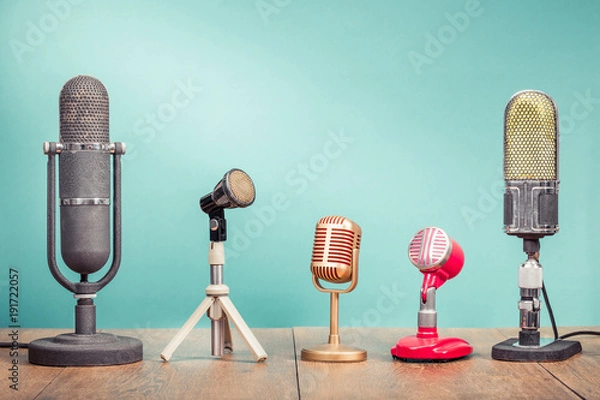 Obraz Retro stare mikrofony do nagrywania konferencji prasowej lub wywiadu na drewnianym stole z przodu gradientowe seledynowe ściany tła. Filtrowane zdjęcie w starym stylu w stylu vintage