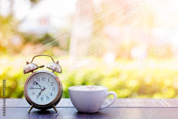 Fototapeta Coffee cappuccino in the morning and an alarm clock.