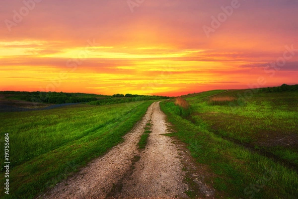 Fototapeta Countryside path on the background of a beautiful sunset