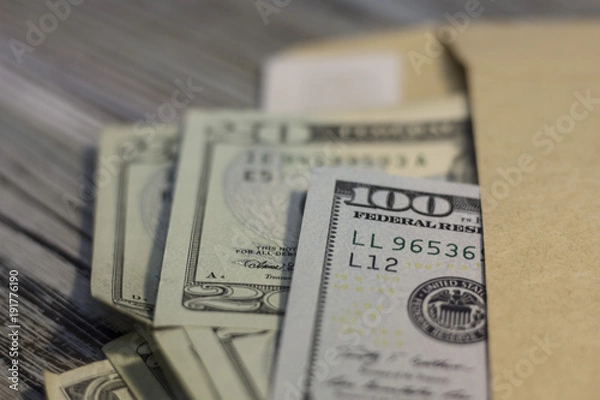 Fototapeta United States money in an envelope on the table. Rough boards background. Money concept. Closeup