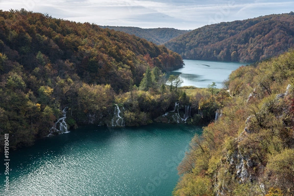 Obraz Two lakes showing the different levels and heights of Plitvice Lakes National Park. This was taken in the fall in Croatia. There are two waterfalls rushing water from the higher elevation to the lower