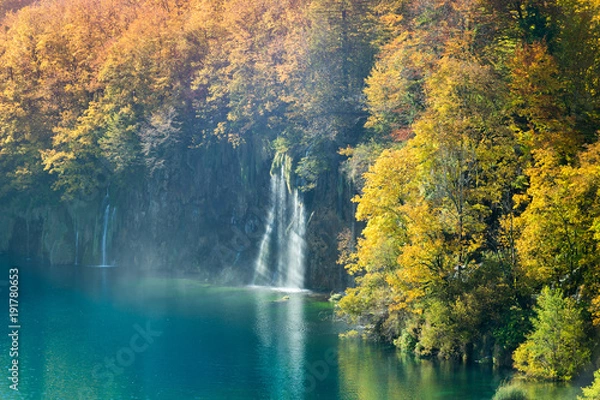Obraz An amazing display of autumn in Plitvice Lakes National Park. The great variance of changing colors of the trees and two waterfalls falling into the turquoise colored lake water.