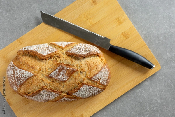 Obraz rustic sourdough bread with bread knife on cutting board top view
