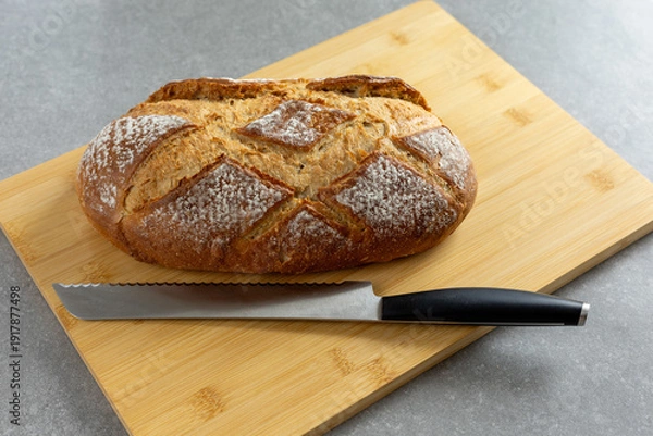 Obraz rustic sourdough bread with bread knife on cutting board