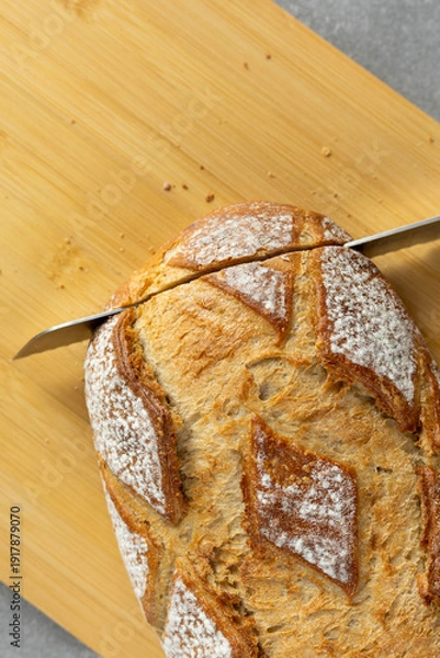 Obraz Slicing rustic bread with knife