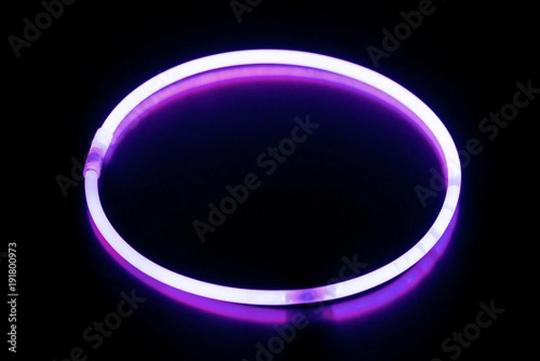 Obraz Round violet glow stick bracelet/ Round violet glow stick bracelet on a black surface with reflection