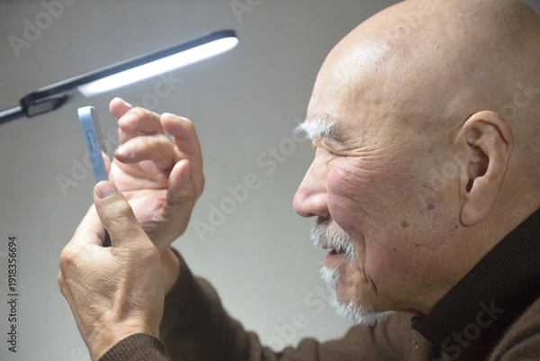 Obraz スマートフォンを操作する老人