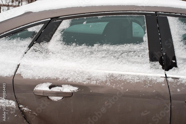 Fototapeta The car in the snow, covered with white snowdrift.
