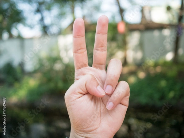 Fototapeta background.Men's hand.Hold two fingers..Be a symbol to fight or not give up.