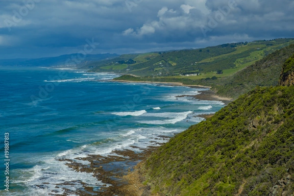 Fototapeta Australian coastline with crashing waves and green hills
