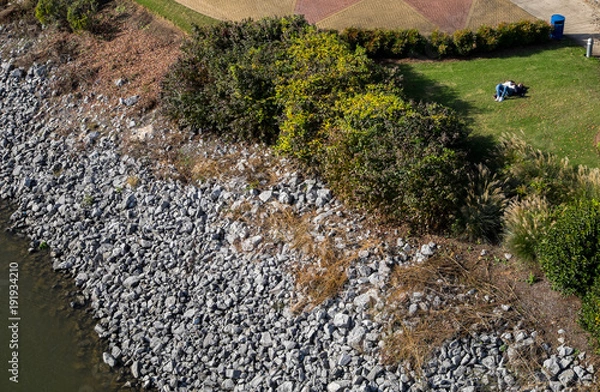 Fototapeta High Angle View of River Shore with Couple Chilling