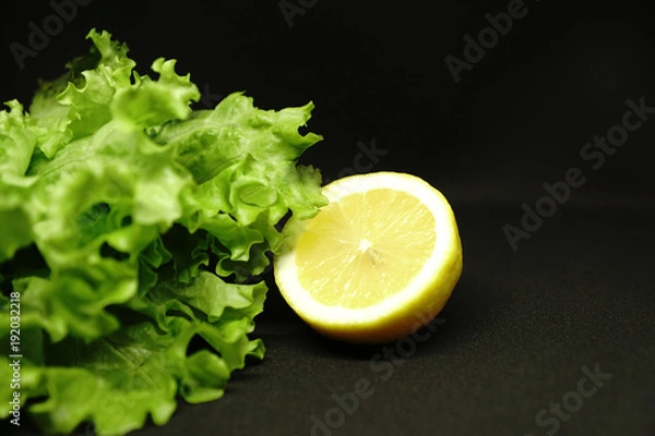 Fototapeta lettuce and lemon on black background