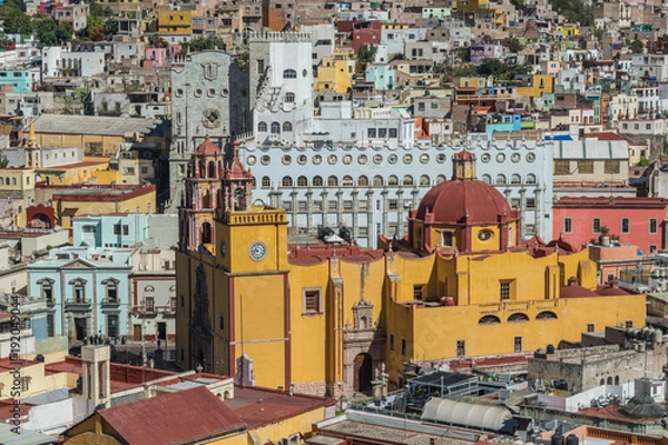 Fototapeta Looking down on a UNESCO Heritage Site-Guanajuato City, Mexico, from up on a hill, with a view of the Basilica, Guanajuato University, many other buildings and colorful houses