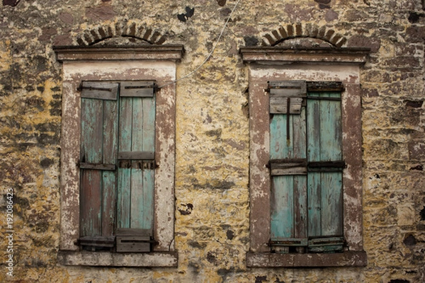 Fototapeta Close up view of old, rusty, closed wooden shutters and stone wa