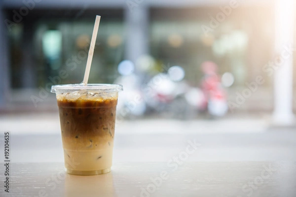 Fototapeta Iced coffee glass on the wood tabel with bokeh light.