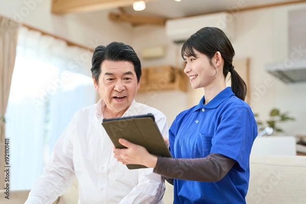 Obraz 訪問介護でタブレットで管理をする介護士