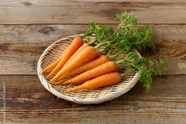 Fototapeta 新鮮な葉付きにんじん(木目背景)