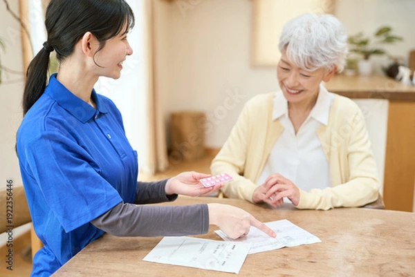 Obraz 訪問介護で服薬介助をするアジア人介護士