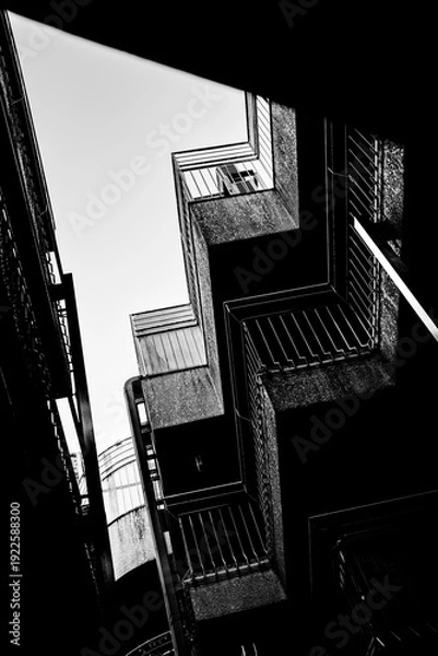 Obraz 都市の路地空間を見上げたモノクロ建築構図