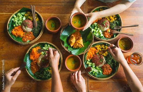 Fototapeta Vegetarian Indian food. several people eat Indian food at a common table together, a view from above.