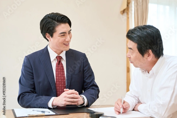 Obraz 士業のサポートで書類を記入するシニア男性