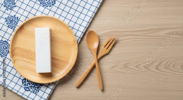 Obraz 明るい木製背景の上の食事用具と白い箱の静物写真