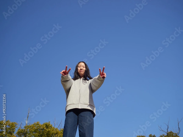 Obraz 春の昼の公園で楽しく遊んでいる十代の女の子の姿