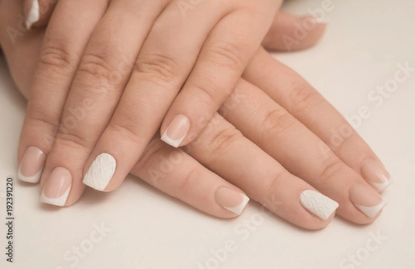 Fototapeta Light manicure in light on a white background.