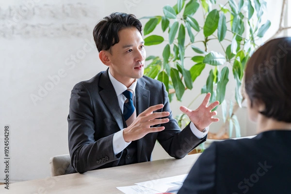 Obraz 資料を使って商談を進めるビジネスミーティングの様子
