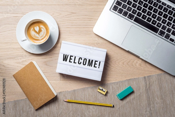 Fototapeta Welcome writing in lightbox lying on desk as flatlay