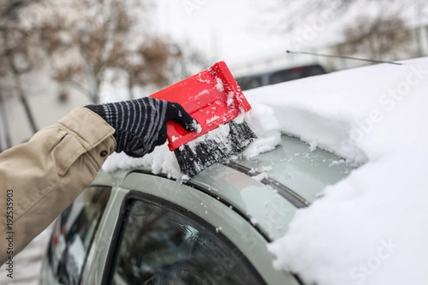 Obraz Cleaning snowy car in winter